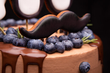 Chocolate cake close-up. Handmade cake. Chocolate cake with decorative elements and blueberries.