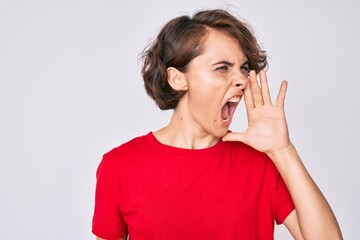 Young hispanic woman wearing casual clothes shouting and screaming loud to side with hand on mouth. communication concept.