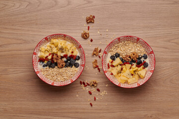 Healthy snacks in bowl: yoghurt, oat flakes, fruit, chia and goji seeds.