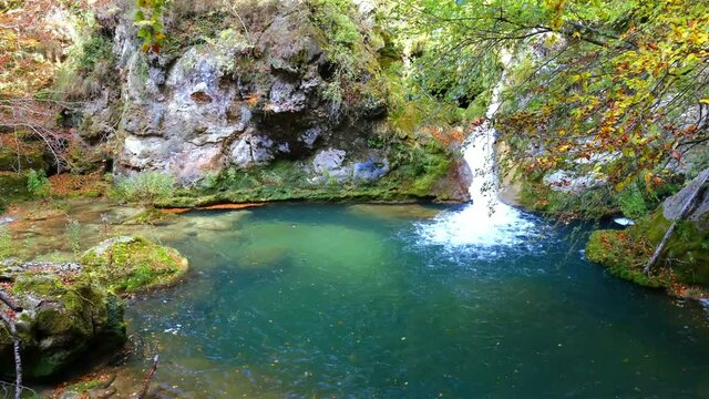River and cascade. Urederra river source in autumn. Urbasa-Andia Natural Park. Navarre, Spain, Europe. 4K.