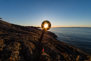 Sunset seen through a ring shaped mooring post