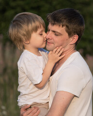 Fototapeta premium Portrait of father and son at meadow in summer