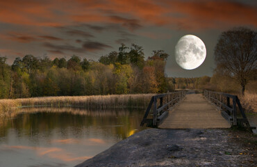 The photo shows the evening moon with a river and a bridge.