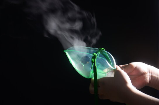 A child's hand holding a nebulizer mask