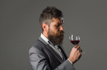 Wine. Bearded man with glass of wine. Tasting alcohol. Red wine. Man with alcohol. Man in suit drinks wine. Man with Bordeaux.