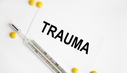 Obraz premium TRAUMA text, next to the thermometer, yellow tablets.