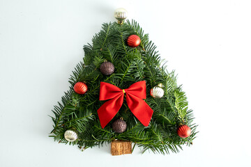 Creative Handmade Christmas tree on a white background, with a red bow and decorative balls