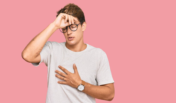 Handsome caucasian man wearing casual clothes and glasses touching forehead for illness and fever, flu and cold, virus sick