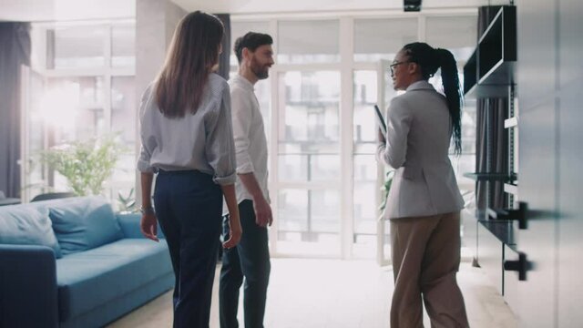 Attractive Couple with real estate agent visiting house for sale or for rent. Buying an apartment. Feel happy smiling at sunlight modern room. Realtor client.