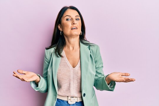 Middle age brunette woman wearing casual clothes clueless and confused with open arms, no idea concept.