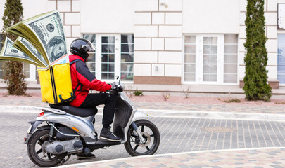 Delivery man in red cap t-shirt uniform driving moped motorbike scooter hold cash money isolated on...