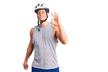 Young handsome man wearing bike helmet smiling positive doing ok sign with hand and fingers. successful expression.