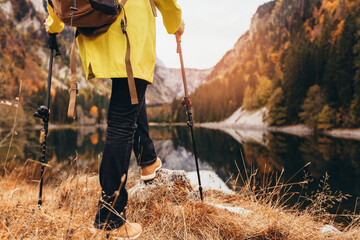 Woman with backpack and raincoat hiking Lifestyle adventure concept forest and lake on background...