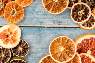 background texture with dried citrus slices on a wooden blue background, space for writing, copy...