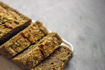 Vegan pumpkin pie with honey, poppy seeds and dried fruits. Homemade cupcake  sugar free cut into pieces on a white table, close-up