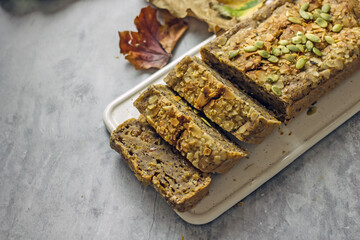 Gluten free and sugar free pumpkin bread cut into pieces. Pumpkin cake with dried fruits, poppy seeds and honey on a dark table. Copy space, flat lay, top view Vegan Pumpkin Pastry