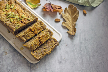 Gluten free and sugar free pumpkin bread cut into pieces. Pumpkin cake with dried fruits, poppy seeds and honey on a dark table. Copy space. Vegan Pumpkin Pastry
