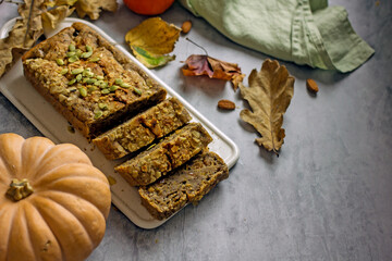 Gluten free and sugar free pumpkin bread cut into pieces. Pumpkin cake with dried fruits, poppy seeds and honey on a dark table. Copy space. Vegan Pumpkin Pastry