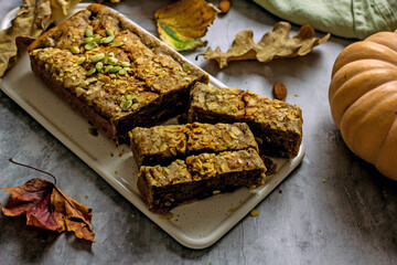 Gluten free and sugar free pumpkin bread cut into pieces. Pumpkin cake with dried fruits, poppy seeds and honey on a dark table. Copy space, flat lay, top view Vegan Pumpkin Pastry