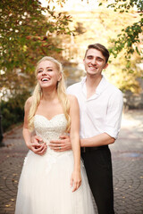 Joyful young couple of lovers dancing together on a wedding day in autumn courtyard