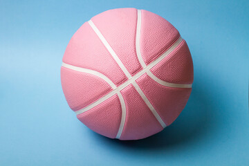 Pink basketball ball on blue background.