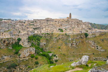 Fototapeta premium Watercolor drawing of Matera panoramic view of historical centre Sasso Caveoso old ancient town Sassi di Matera with cave rock houses with dramatic sky, view from Murgia Timone, Basilicata, Italy