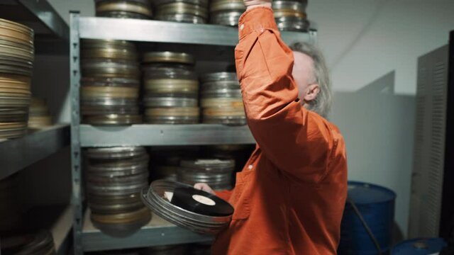 A man in a film tape warehouse inspected a piece of old film.
