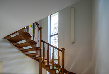 Close-up of wooden staircase to the second floor in private house. Luxury interior of apartment.