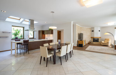 Contemporary interior of luxury apartment. Dark wooden table and cozy chairs. Living room with fireplace. Private house.