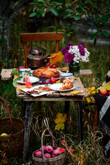 Apple buns with caramel on a wooden table in an autumn garden