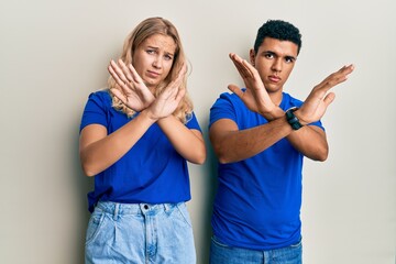 Young interracial couple wearing casual clothes rejection expression crossing arms doing negative sign, angry face