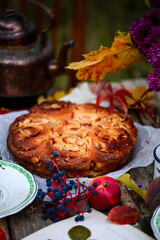 Apple buns with caramel on a wooden table in an autumn garden