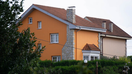 Casa naranja enfocada, con desenfoque en la vegetación.