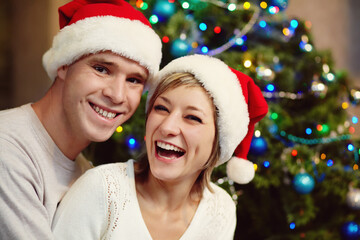 young couple celebrating Christmas at home. man and woman in with a gift box