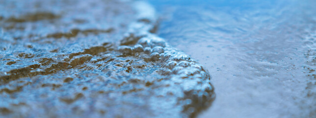 Photography of surf. Waves of the Atlantic Ocean in the Bay of Biscay run onto the sandy shore in summer day. Natural fresh background for poster, banner, postcard, greeting card, touristic guide