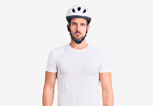Young handsome man wearing bike helmet depressed and worry for distress, crying angry and afraid. sad expression.