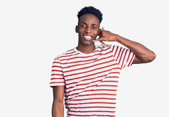 Young african american man wearing casual clothes smiling doing phone gesture with hand and fingers like talking on the telephone. communicating concepts.