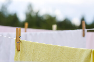 Washed cotton bed sheets hanging on a clothesline outdoors