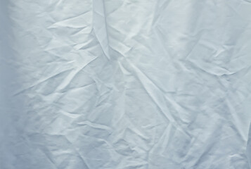 Washed laundry hanging on a clothesline outdoors. Wrinkled bed sheet fabric.