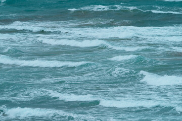 Photography of surf. Big waves of the Atlantic Ocean in the Bay of Biscay run onto the sandy shore in summer day. Natural fresh background for poster, banner, postcard, greeting card, touristic guide