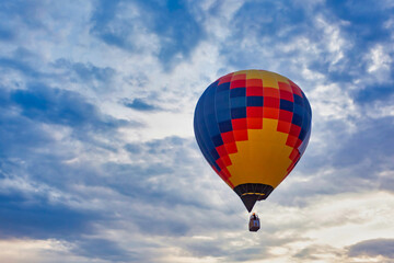 Blue red yellow balloon against cloudy sky