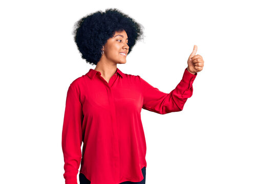 Young african american girl wearing casual clothes looking proud, smiling doing thumbs up gesture to the side