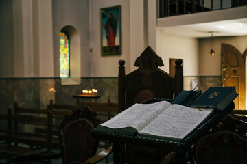The open Bible in armenian language lying in the empty dark Armenian Church
