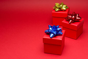 Red gift box with colored ribbon on red background