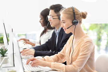 Team of hotline operators with headsets communicating to clients at modern call center, free space