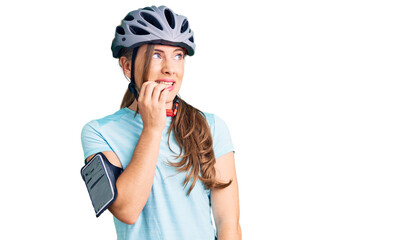 Beautiful caucasian young woman wearing bike helmet looking stressed and nervous with hands on mouth biting nails. anxiety problem.