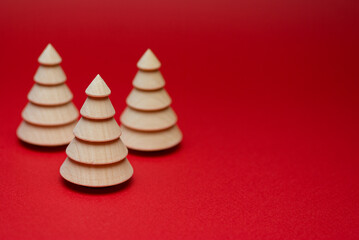 Wooden Christmas tree figurine on a red background. Copy space.