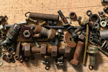 old vintage hand tools - set of screws and nuts on a wooden background