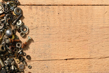 old vintage hand tools - set of screws and nuts on a wooden background with blank space for text