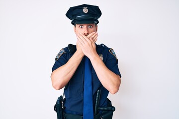 Young caucasian man wearing police uniform shocked covering mouth with hands for mistake. secret concept.